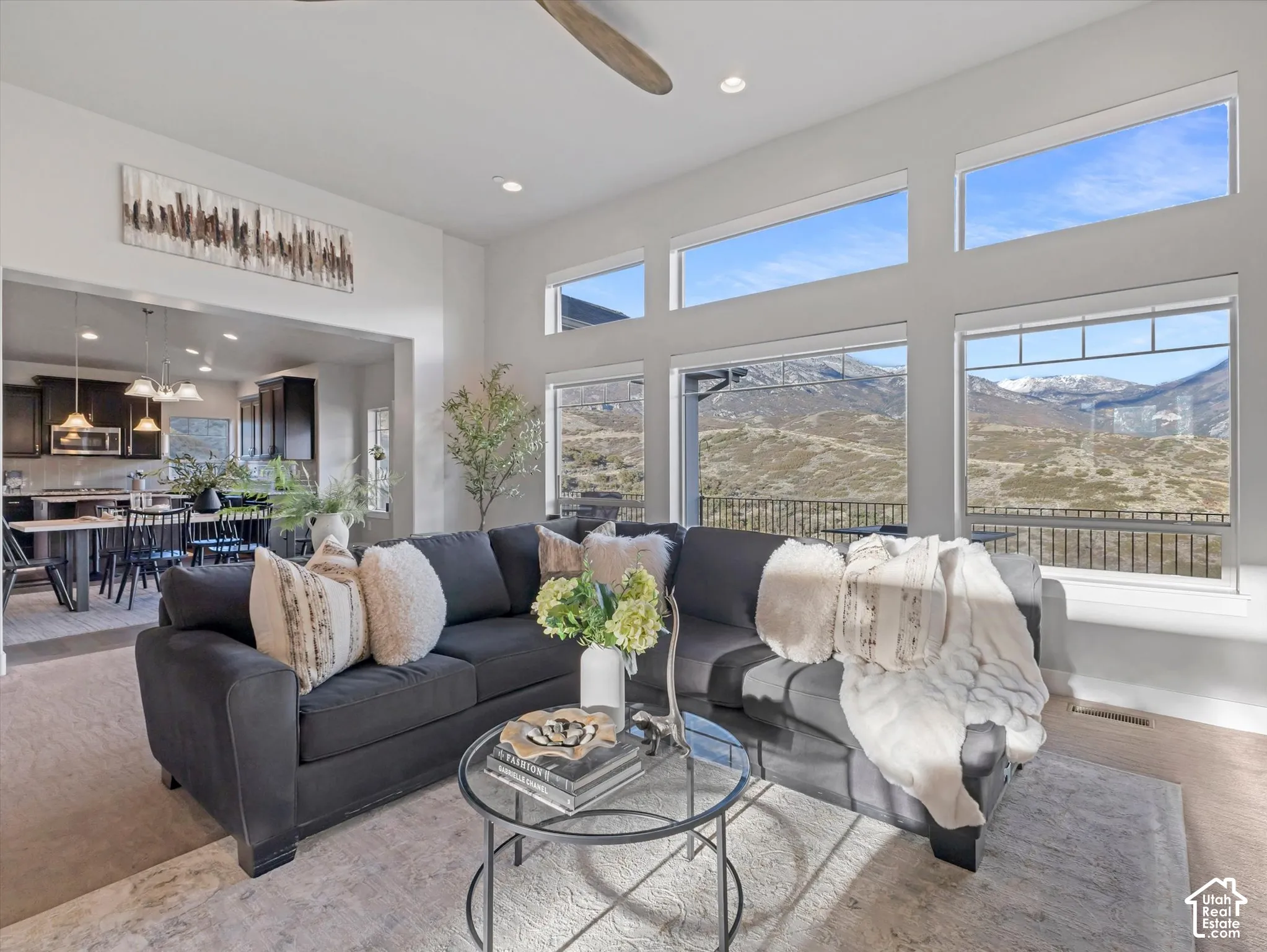 Great room featuring vaulted ceilings, floor-to-ceiling windows, mountain scenery, recessed lighting, and a ceiling fan