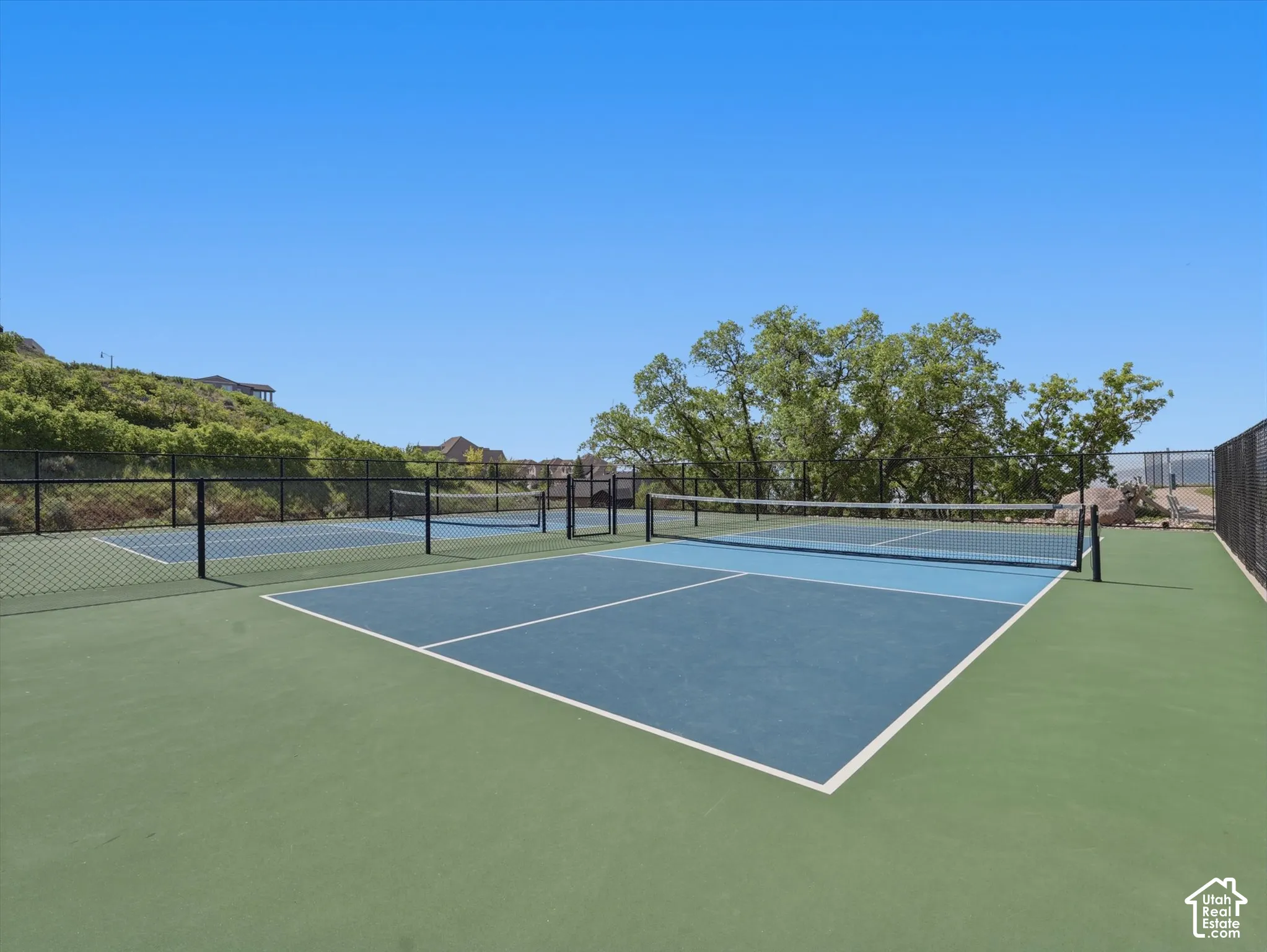 Dual multi-purpose sport courts featuring paved surfacing, painted court lines, and perimeter chain-link fencing
