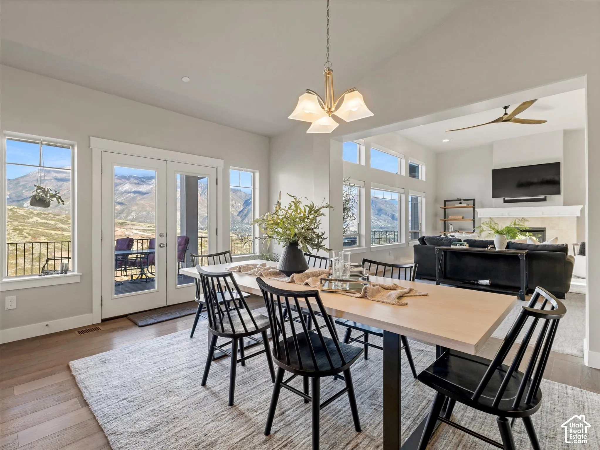 Dining area featuring wood-finish flooring, a multi-light metal chandelier, and floor-to-ceiling windows providing mountain scenery