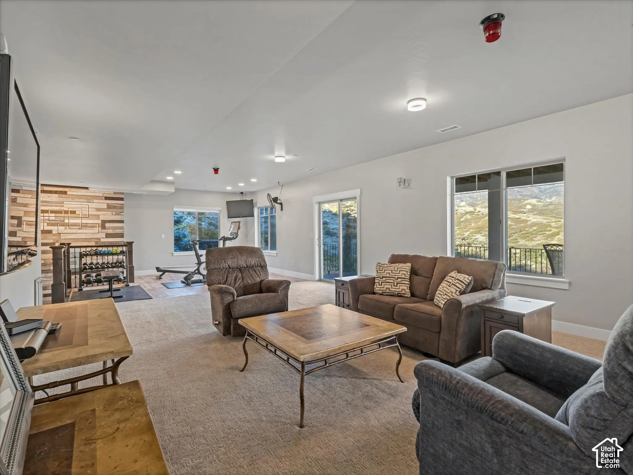 Open floor plan featuring wall-to-wall carpeting, recessed lighting, and a textured accent wall