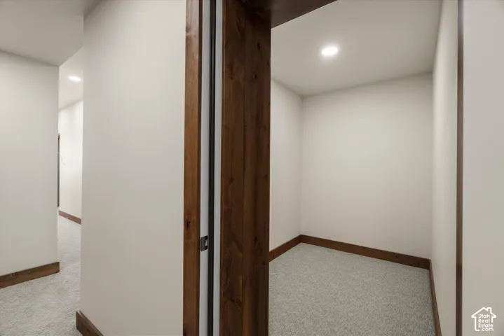 Interior space featuring neutral-toned carpeting, recessed lighting, and stained wood trim throughout