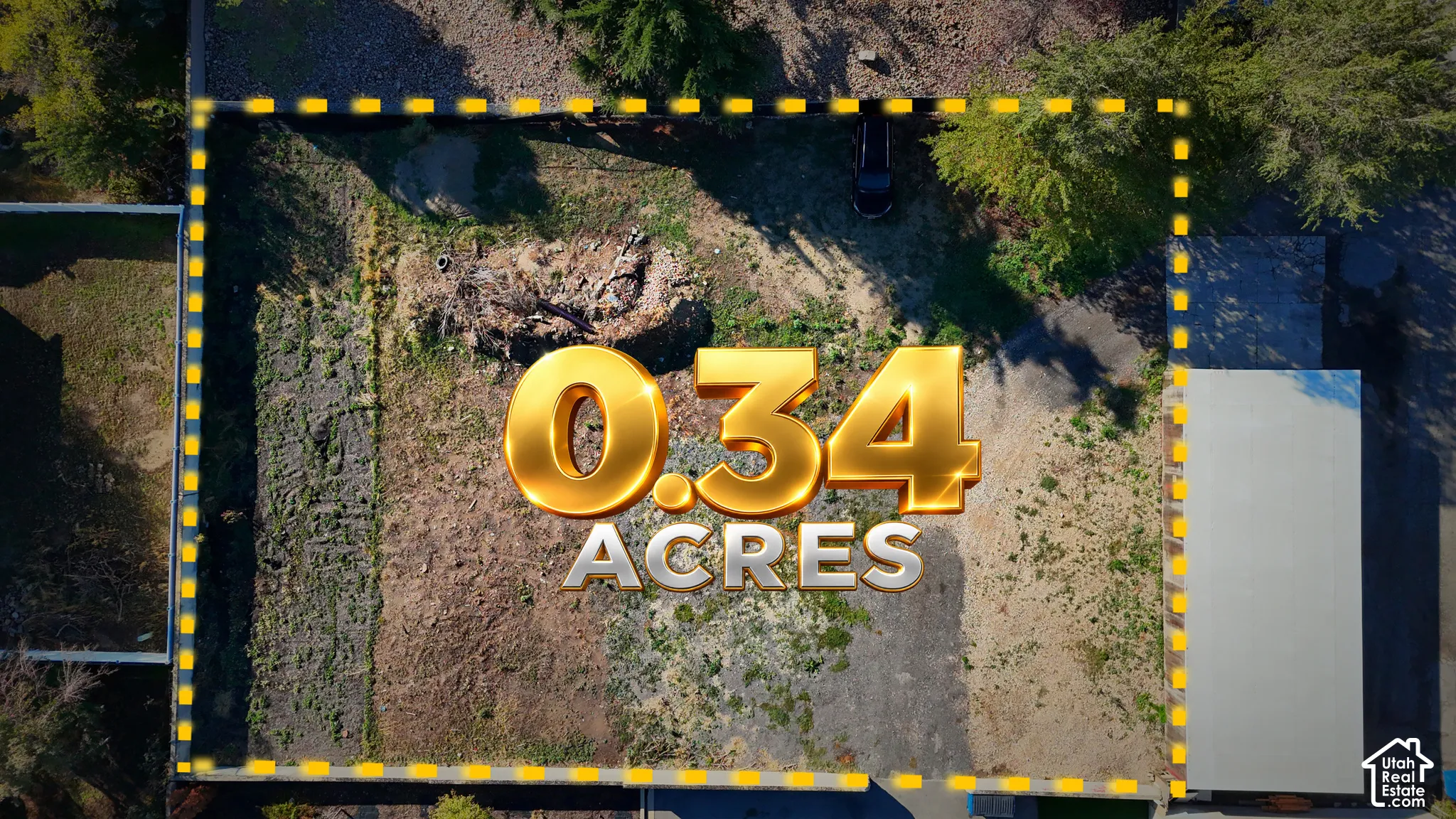 0.34-acre parcel featuring mature trees, a paved driveway, and established perimeter vegetation