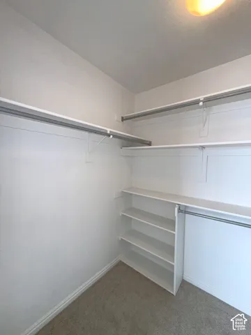 Storage closet featuring tiered shelving, built-in organizers, and dual-level hanging rods