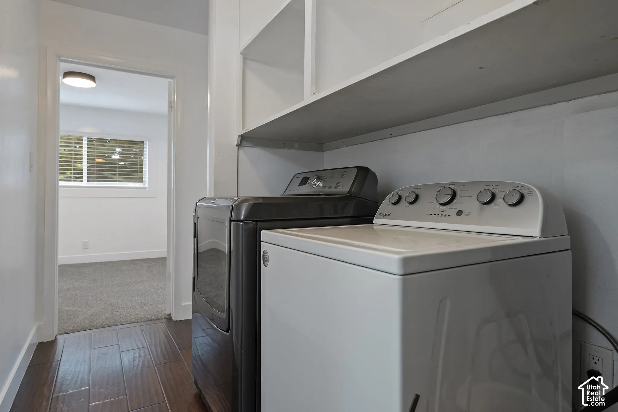 Laundry area featuring built-in white shelving, wood-finish flooring, and recessed ceiling lighting