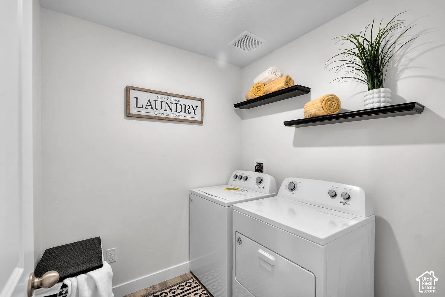 Laundry area featuring dual black wall-mounted floating shelves
