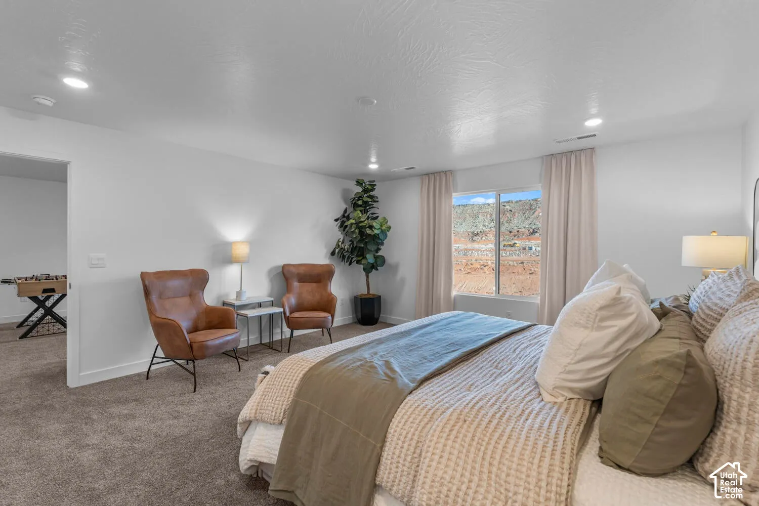 Neutral-toned carpet, recessed lighting, and a window featuring an exterior landscape backdrop