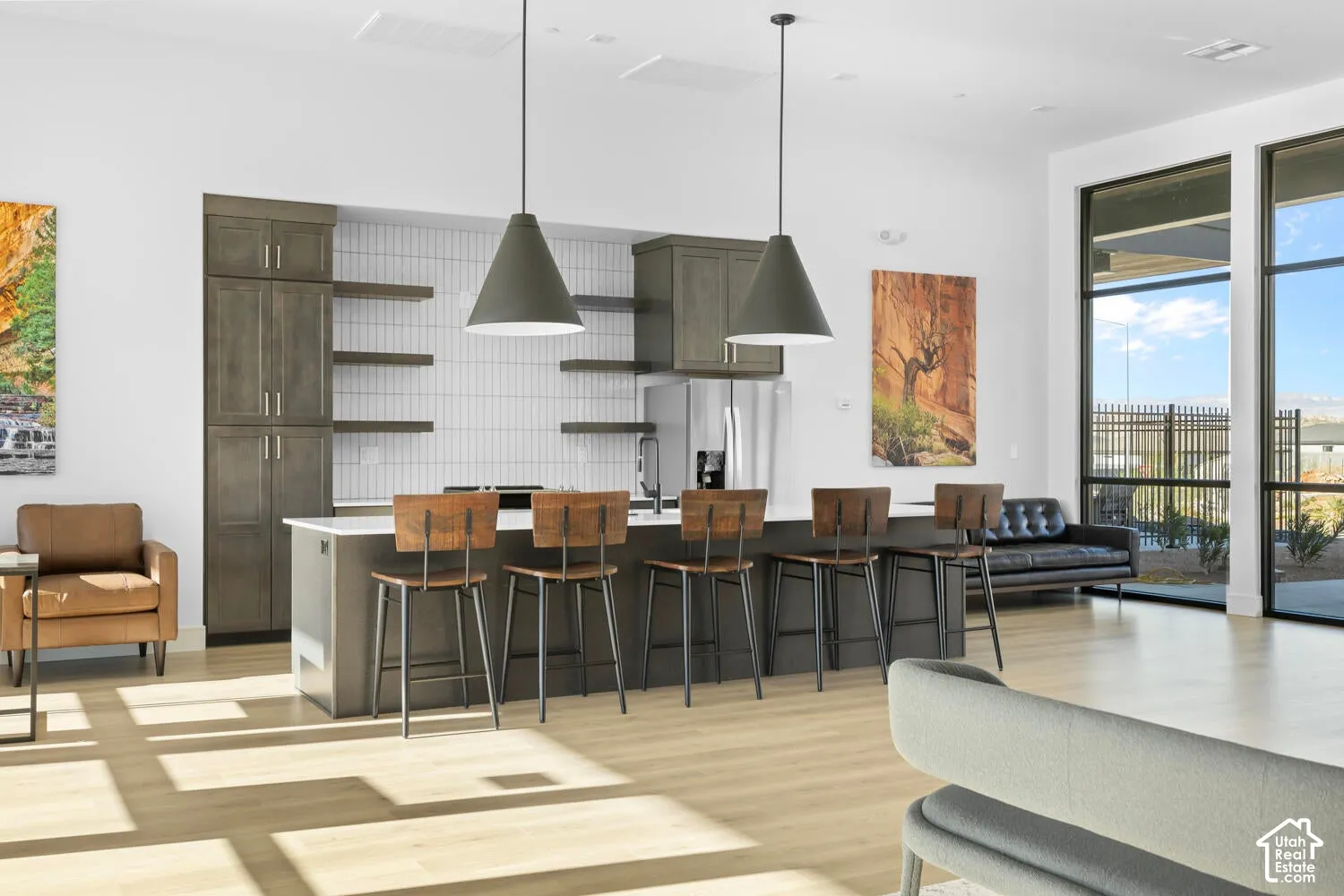 Kitchen featuring a central island with countertop seating, vertical tile backsplash, wood-finish cabinetry, open shelving, and full-height windows