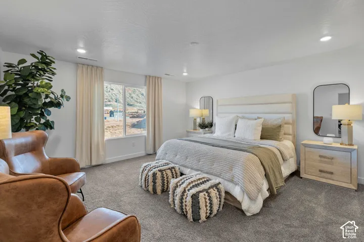 Spacious room featuring neutral carpeting, recessed lighting, and a large picture window