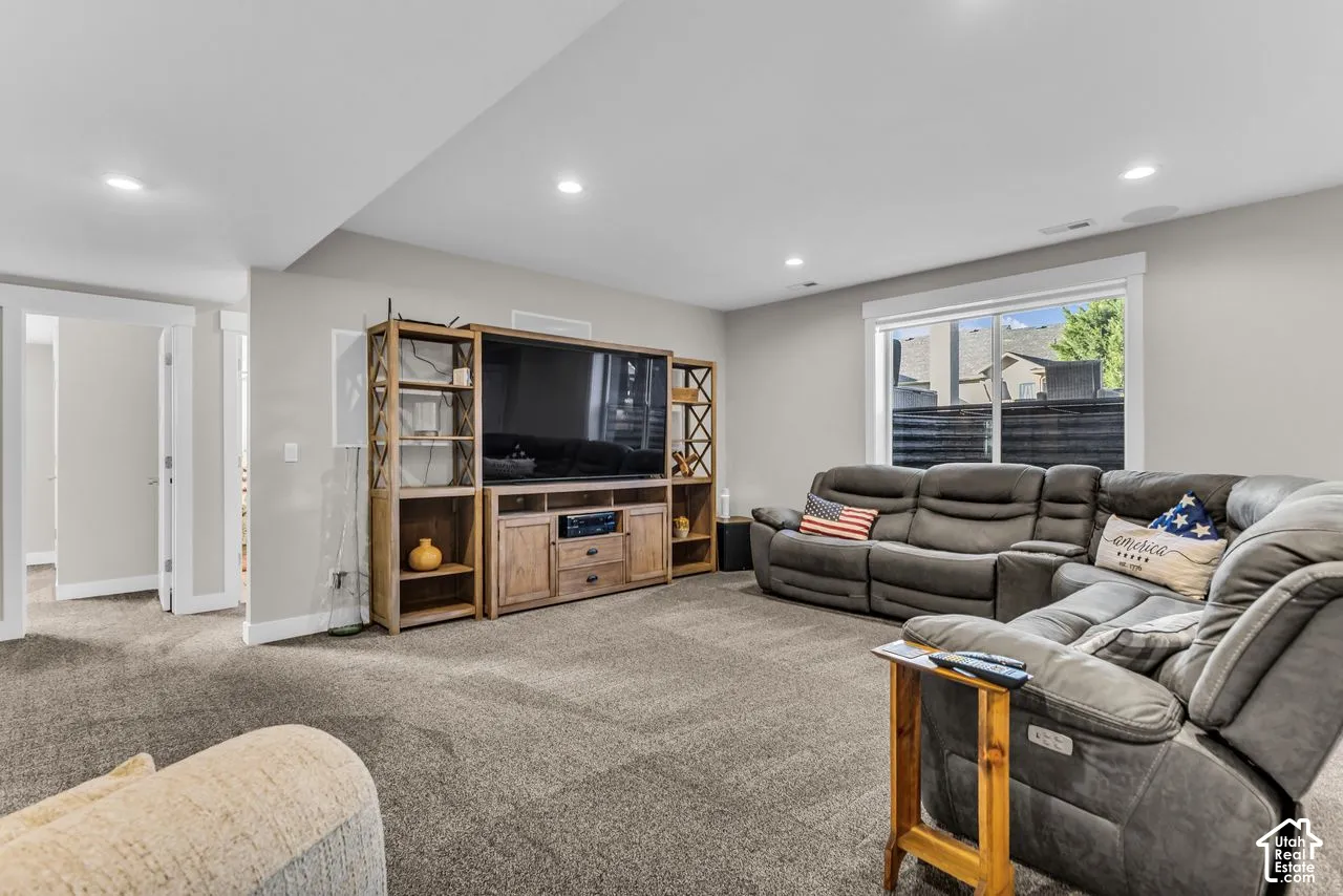 Recessed lighting, wall-to-wall carpeting, and a large window featuring natural light