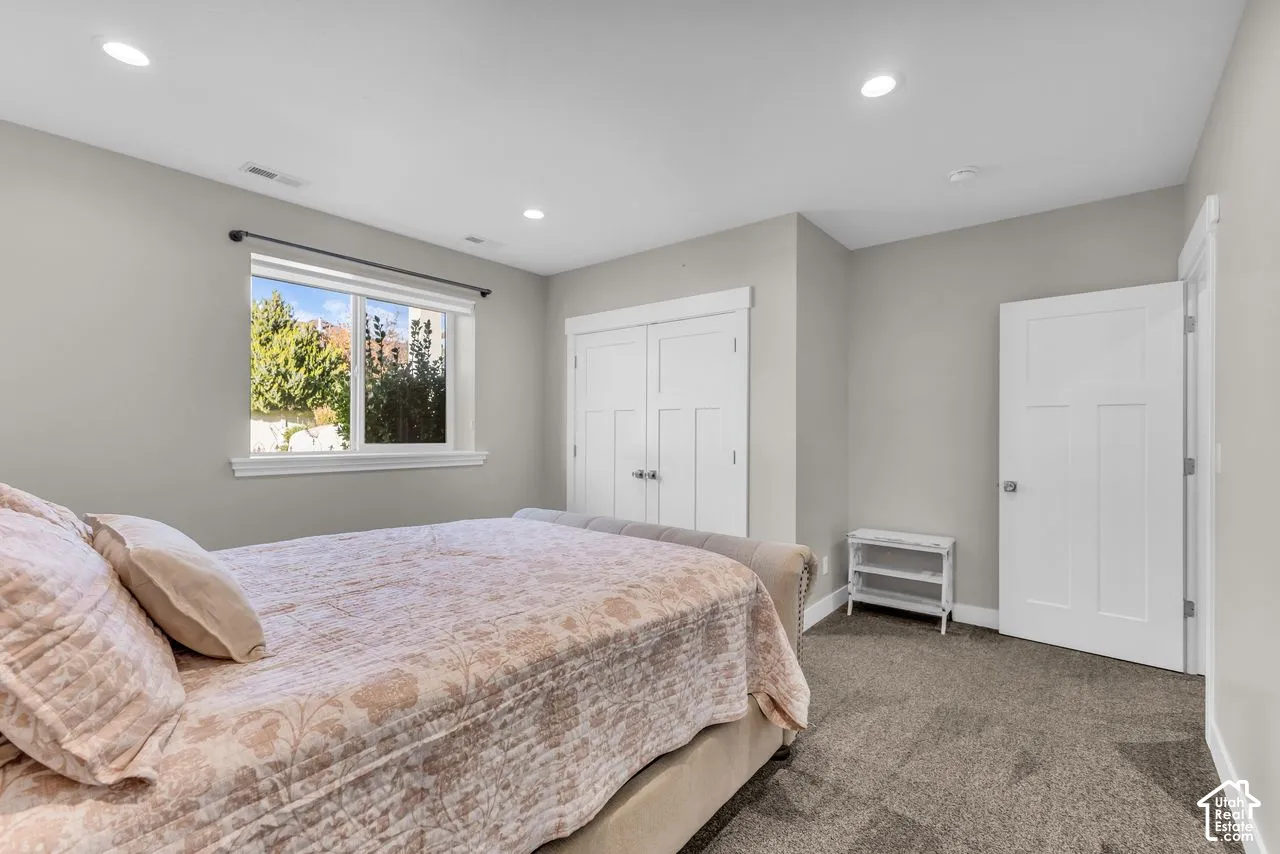 Interior space featuring neutral wall paint, recessed lighting, carpeted flooring, a multi-panel door, and a dual-panel closet door
