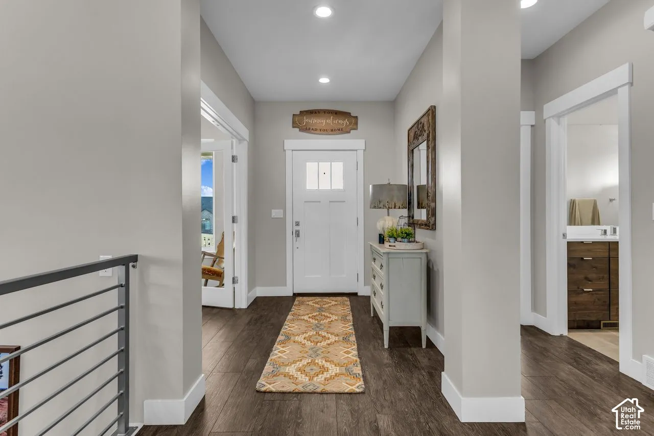 Entryway featuring wood-finish flooring, recessed lighting, a multi-pane glass door, and a metal horizontal-bar railing