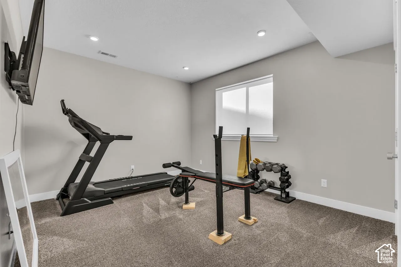 Neutral-toned walls, recessed lighting, wall-to-wall carpeting, and a rectangular window with a wide sill