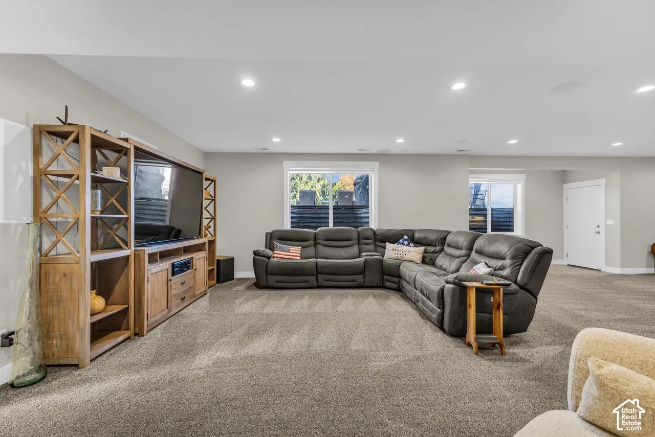 Open-concept interior featuring recessed lighting, neutral wall paint, and integrated shelving surrounding a recessed media space