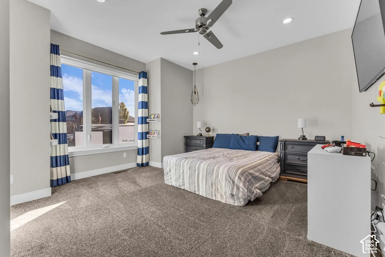 Neutral wall palette featuring expansive windows, recessed lighting, carpeted flooring, and a ceiling-mounted fan with integrated lighting