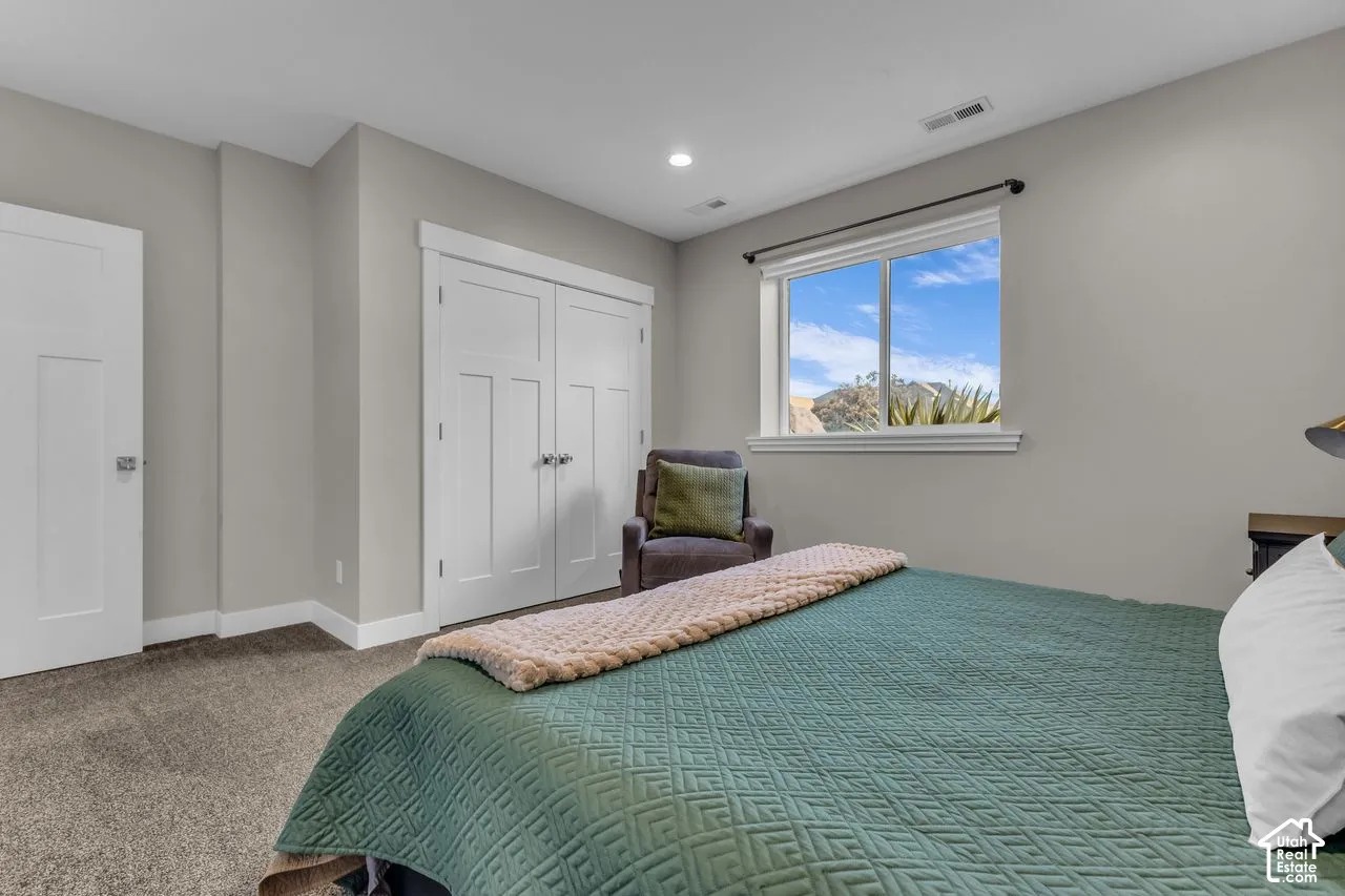 Neutral wall tones, carpeted flooring, double-panel closet doors with hardware, recessed lighting, and mountain scenery