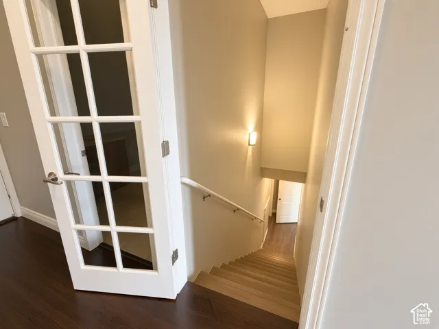 French door featuring a multi-pane glass design with satin nickel hardware, wood-finish stairs, and a wall-mounted handrail