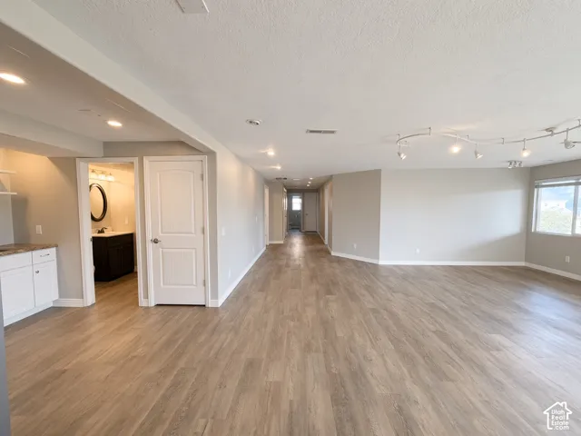 Open-concept space featuring wood-finish flooring, recessed lighting, adjustable track lighting, and neutral wall tones