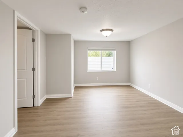 Neutral wall palette, wood-finish flooring, sliding window with integrated blinds, and a semi-flush mount ceiling fixture