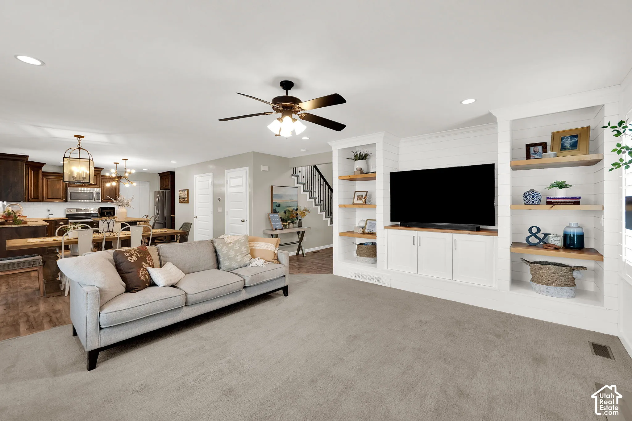 Built-in white cabinetry with wood-finish shelving and shiplap detailing, recessed lighting, and a ceiling fan