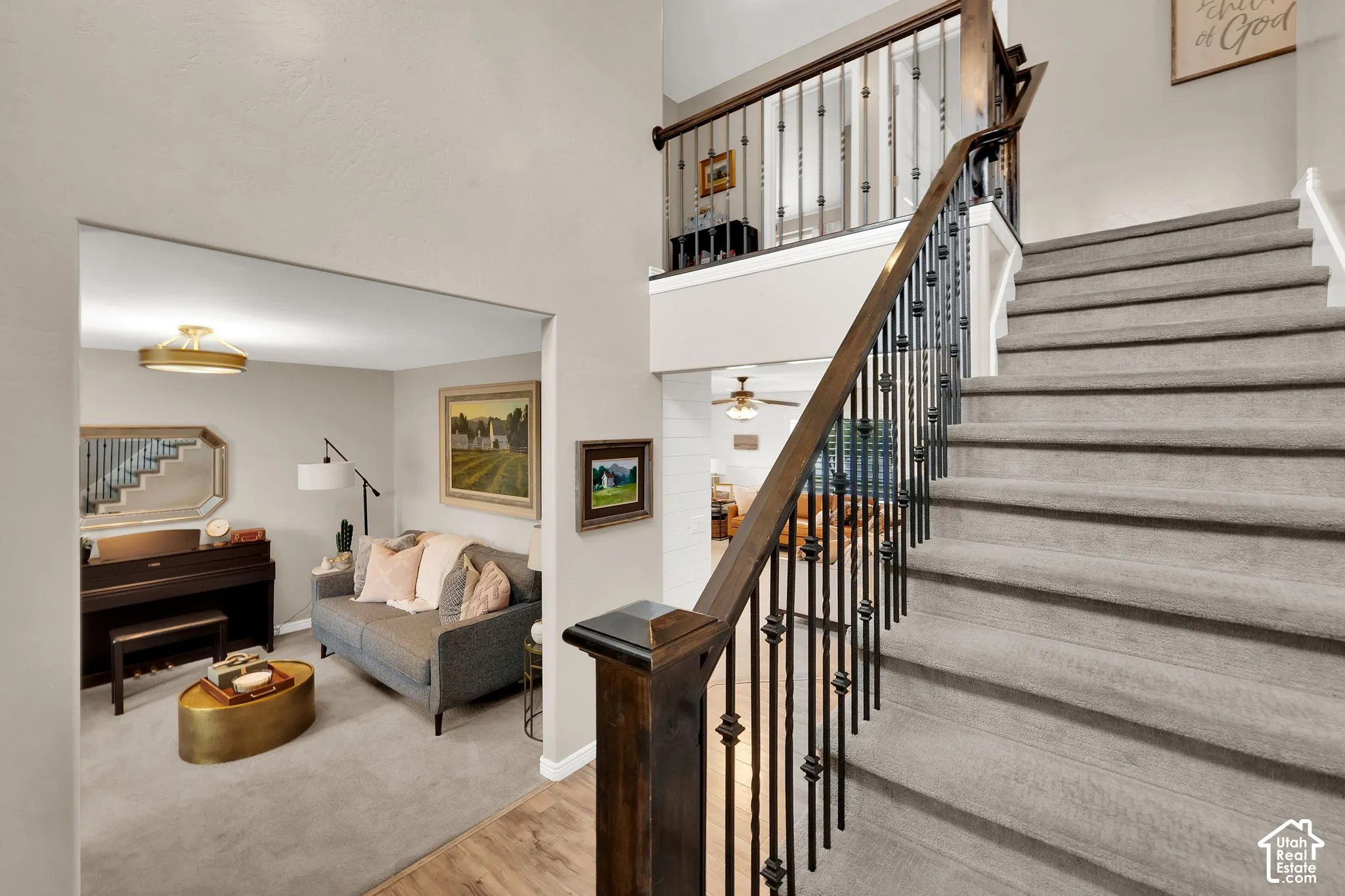 Foyer featuring a two-story ceiling, a staircase with carpeted treads, and a custom dark wood railing with decorative metal balusters