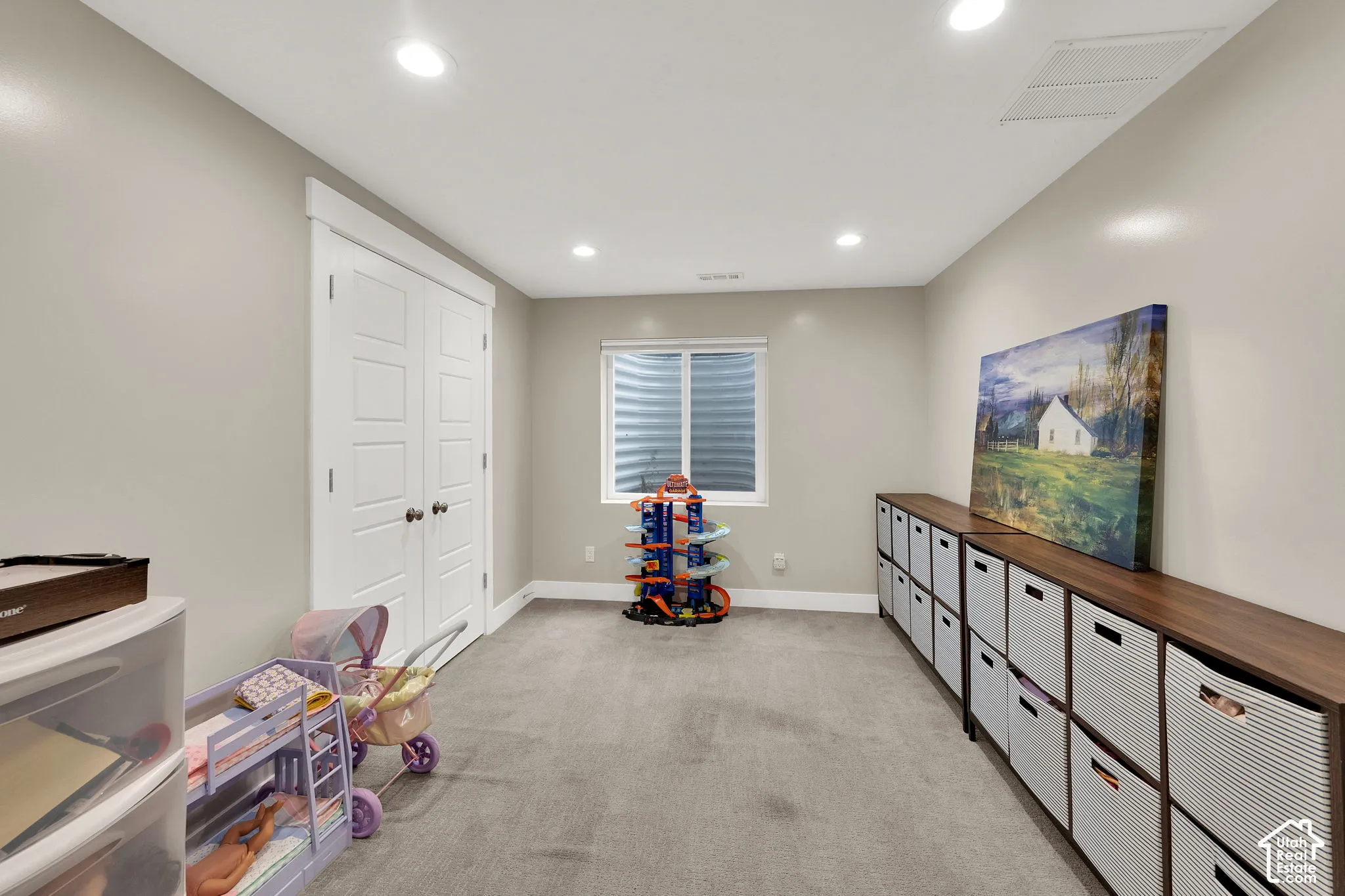 Neutral-toned interior featuring recessed lighting, wall-to-wall carpeting, a double-door closet, and an egress window with a corrugated metal window well