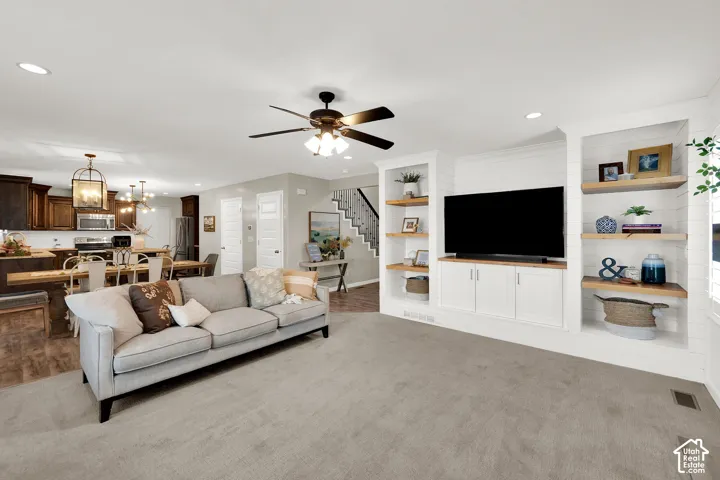 Built-in white cabinetry with wood-finish shelving and shiplap detailing, recessed lighting, and a ceiling fan