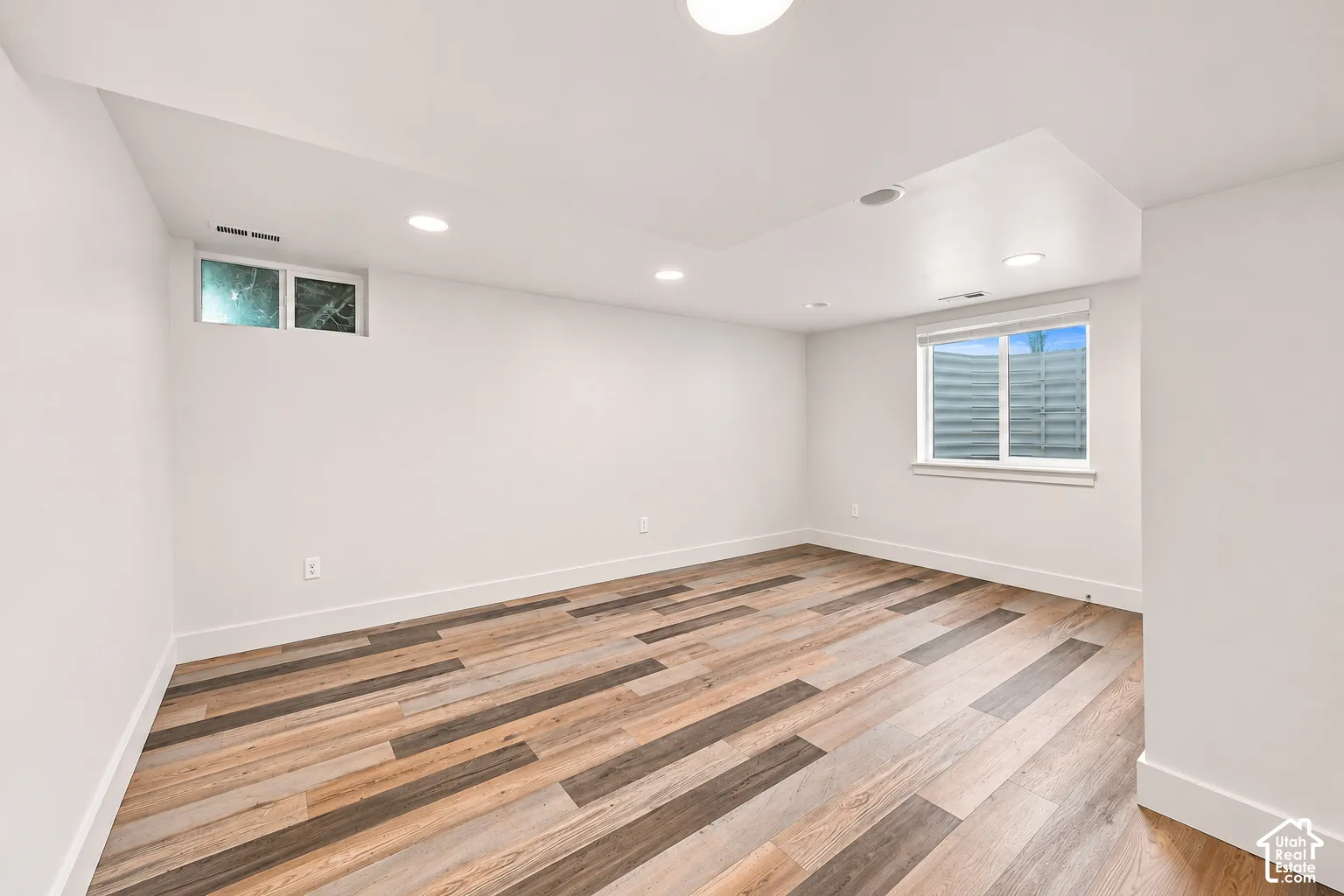Interior room featuring wood-finish flooring, recessed lighting, and dual windows