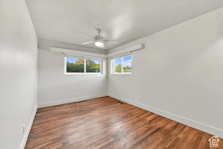 Interior space featuring wood-finish flooring, two sliding windows, and a ceiling-mounted light fixture with a fan