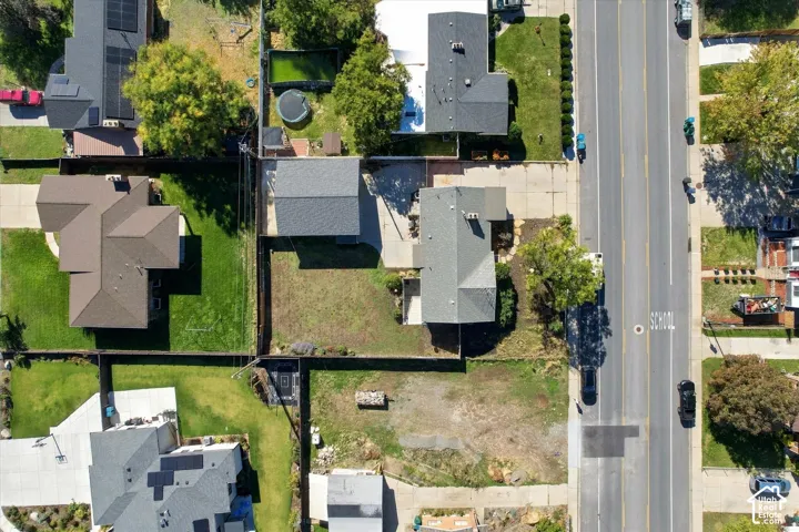 Aerial perspective featuring a detached garage, concrete driveway, and fenced perimeter