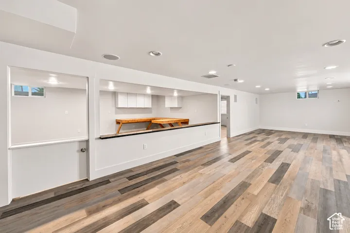 Multi-purpose area featuring wood-finish flooring, recessed lighting, built-in counter space, and wall-mounted cabinetry
