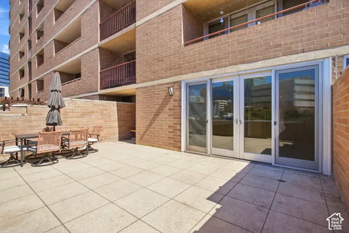 Private terrace featuring large-format tile flooring, brick walls, and multi-panel sliding glass doors