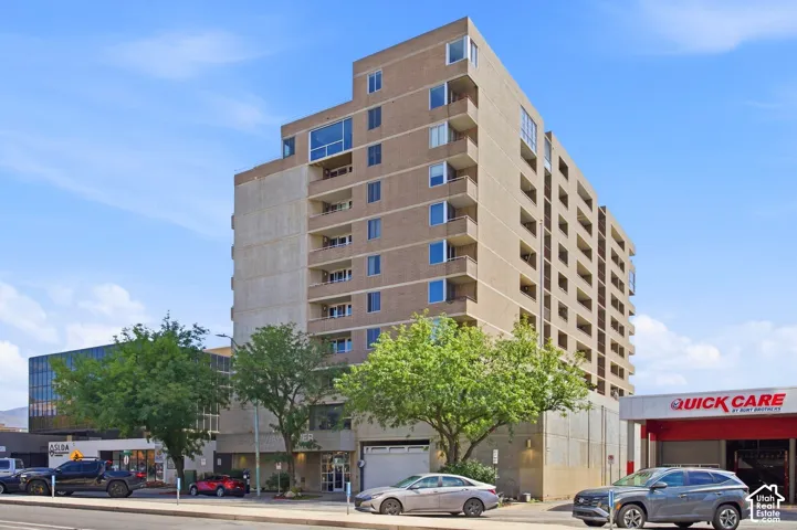 Mid-rise brick exterior featuring stacked private balconies and a ground-level gated entrance
