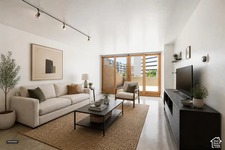 Polished concrete flooring, adjustable track lighting, and wood-framed sliding glass doors opening to a private balcony