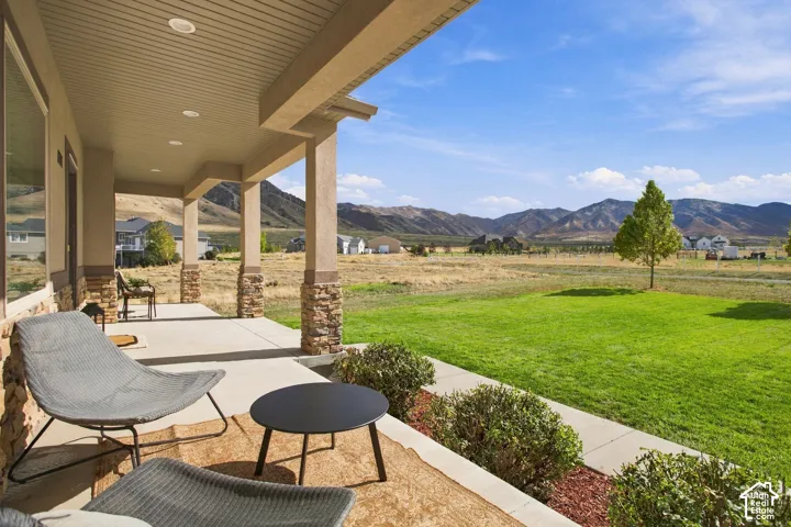 Covered porch featuring recessed lighting, and expansive mountain terrain backdrop