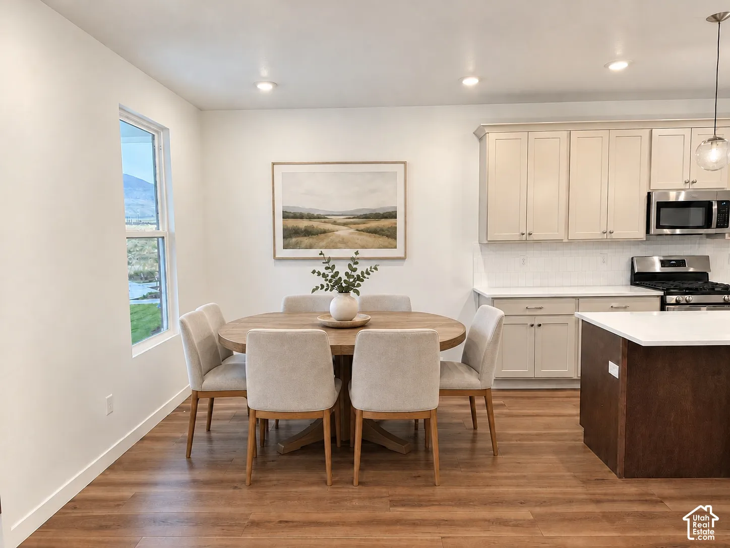 Kitchen featuring shaker-style cabinetry, a contrasting central island with a white countertop, recessed lighting, and wood-finish flooring