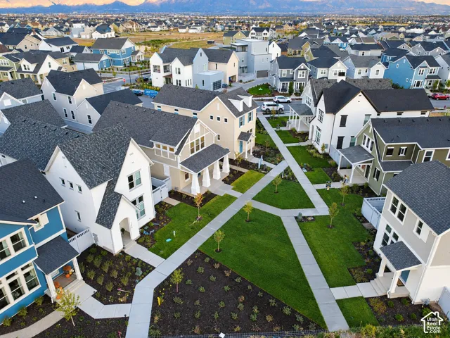 Aerial perspective of residential exteriors featuring multi-story architectural designs, pitched roofs, concrete walkways, and manicured green spaces
