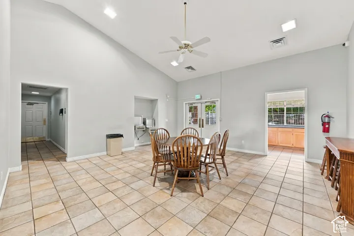 Vaulted ceilings, neutral wall finishes, tile flooring, recessed lighting, and a ceiling fan