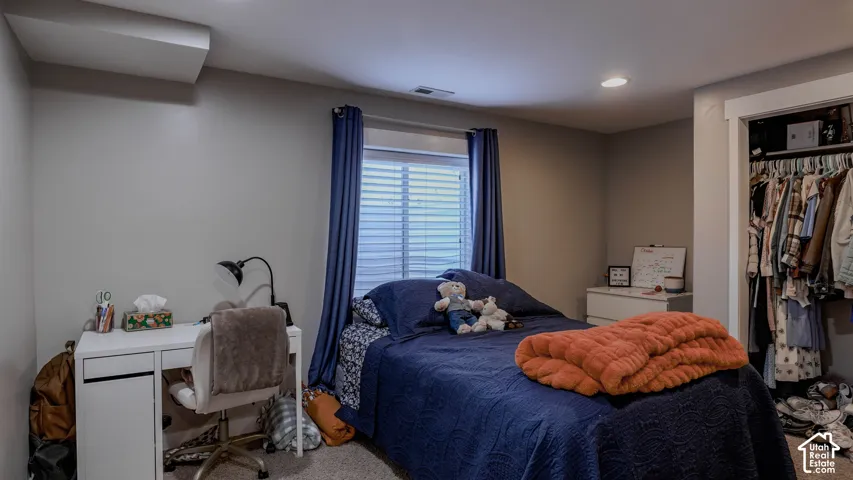 Neutral interior featuring wall-to-wall carpeting, recessed ceiling lighting, and a reach-in closet with built-in shelving
