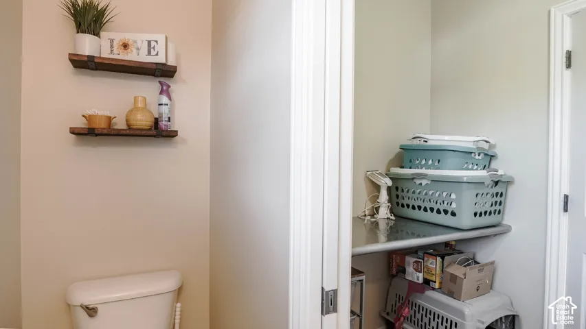 Wall-mounted rustic wooden shelving with metal brackets and a utility closet featuring a fixed storage shelf