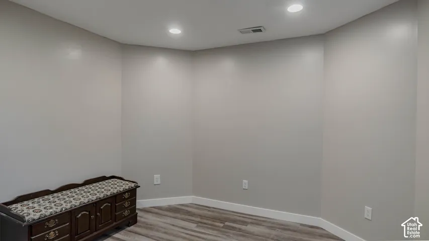 Neutral-toned walls, wood-finish flooring, and recessed ceiling lighting