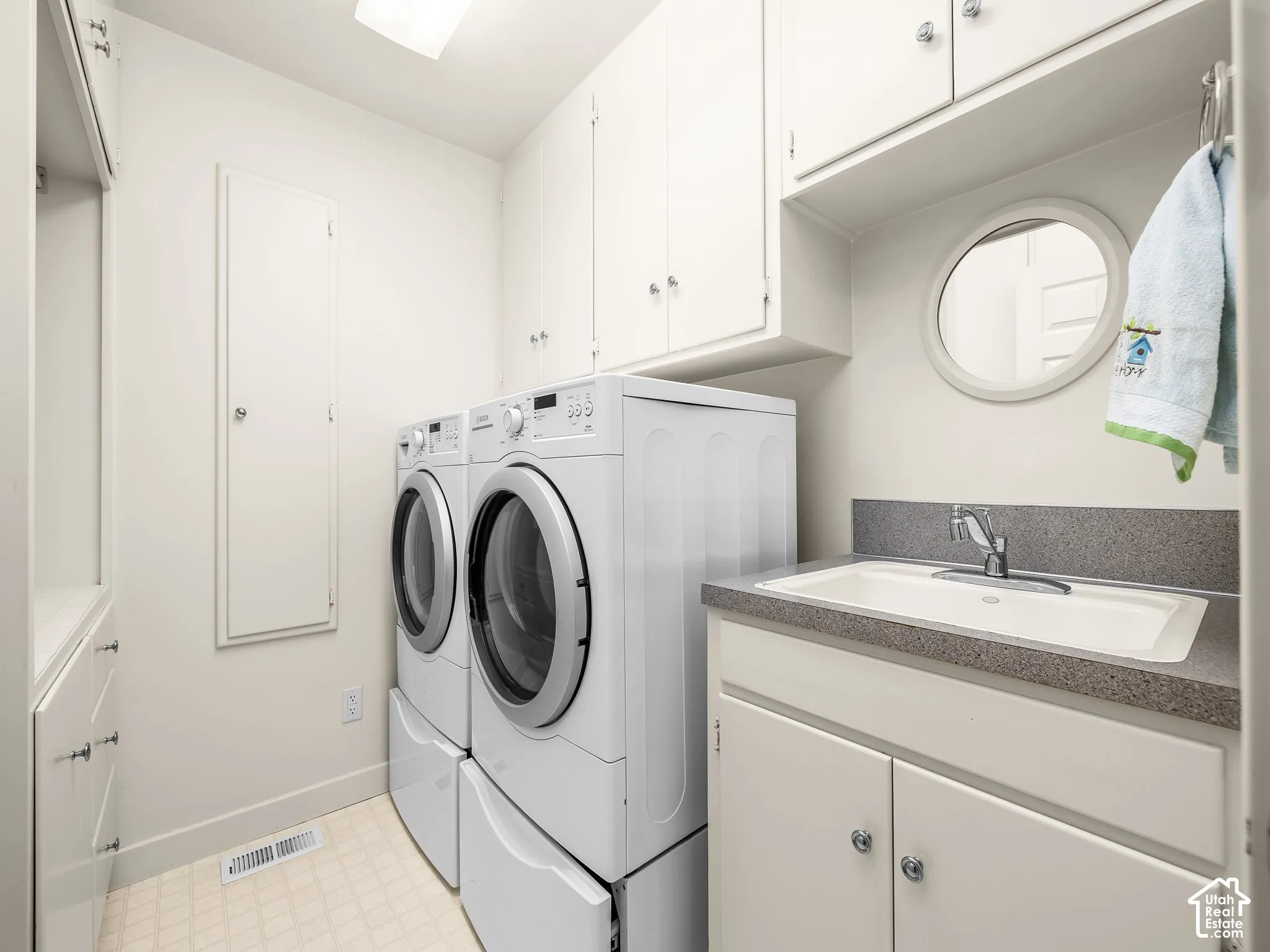 Laundry room with sink and built in cabinets.