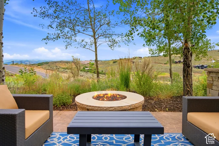 Patio featuring a circular stone fire pit and natural mountain terrain backdrop