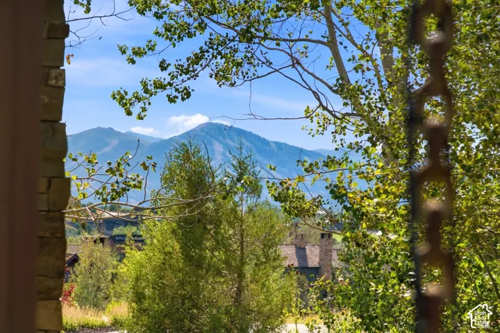 Mountain backdrop with stone pillar exterior accents and metal chain-style downspout