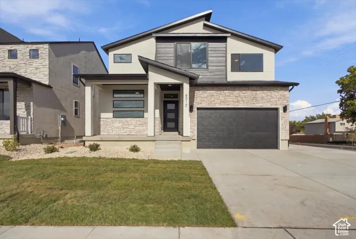 Quick Move In! Modern exterior featuring a mix of stone veneer and horizontal siding, shed-style rooflines, multi-pane entry door, attached two-car garage, and a covered front porch