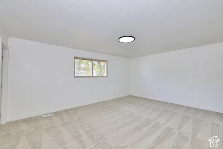 Room featuring neutral wall-to-wall carpeting, crisp white walls, and a recessed ceiling light fixture