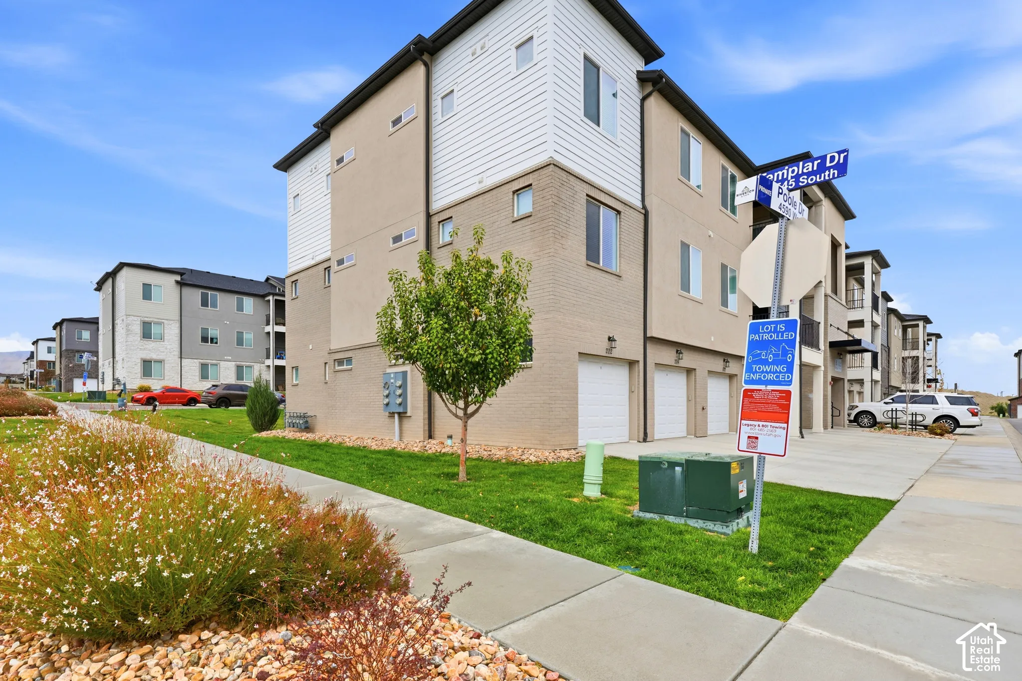 Multi-level exterior featuring a combination of brick and horizontal siding, multiple attached garages, and a concrete driveway