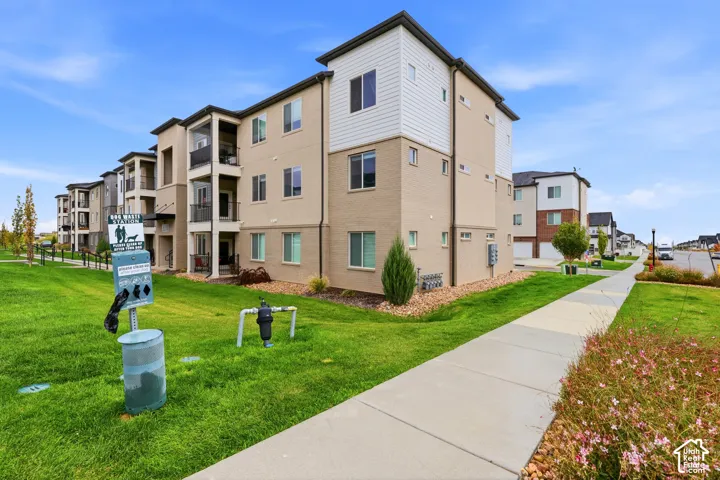 Multi-story exterior featuring a brick and horizontal siding facade, covered balconies, and concrete walkways