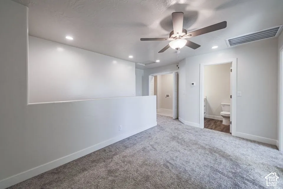 Interior space featuring neutral wall-to-wall carpeting, recessed ceiling lighting, and a multi-blade ceiling fan
