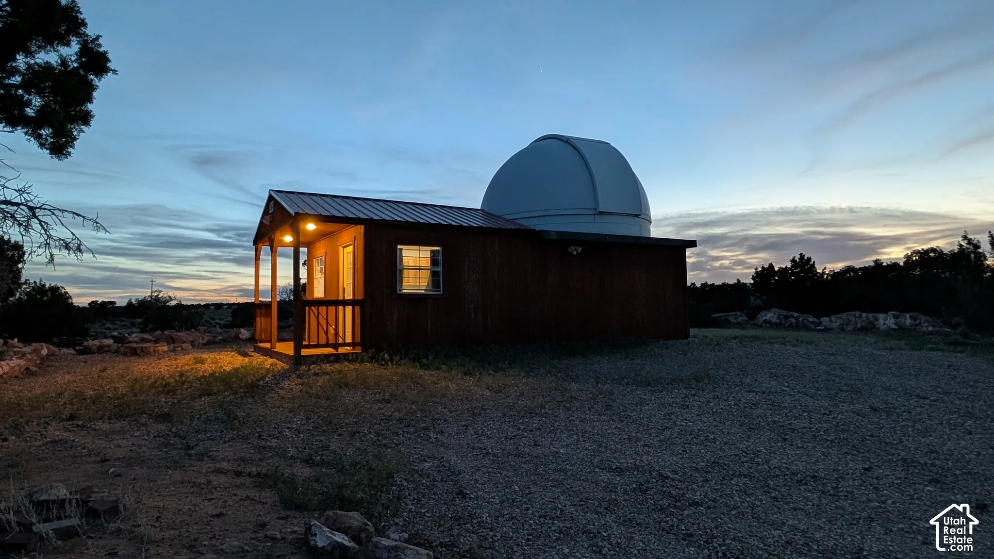 Exterior structure featuring a built-in observatory dome, metal roofing, wood siding, and a covered porch