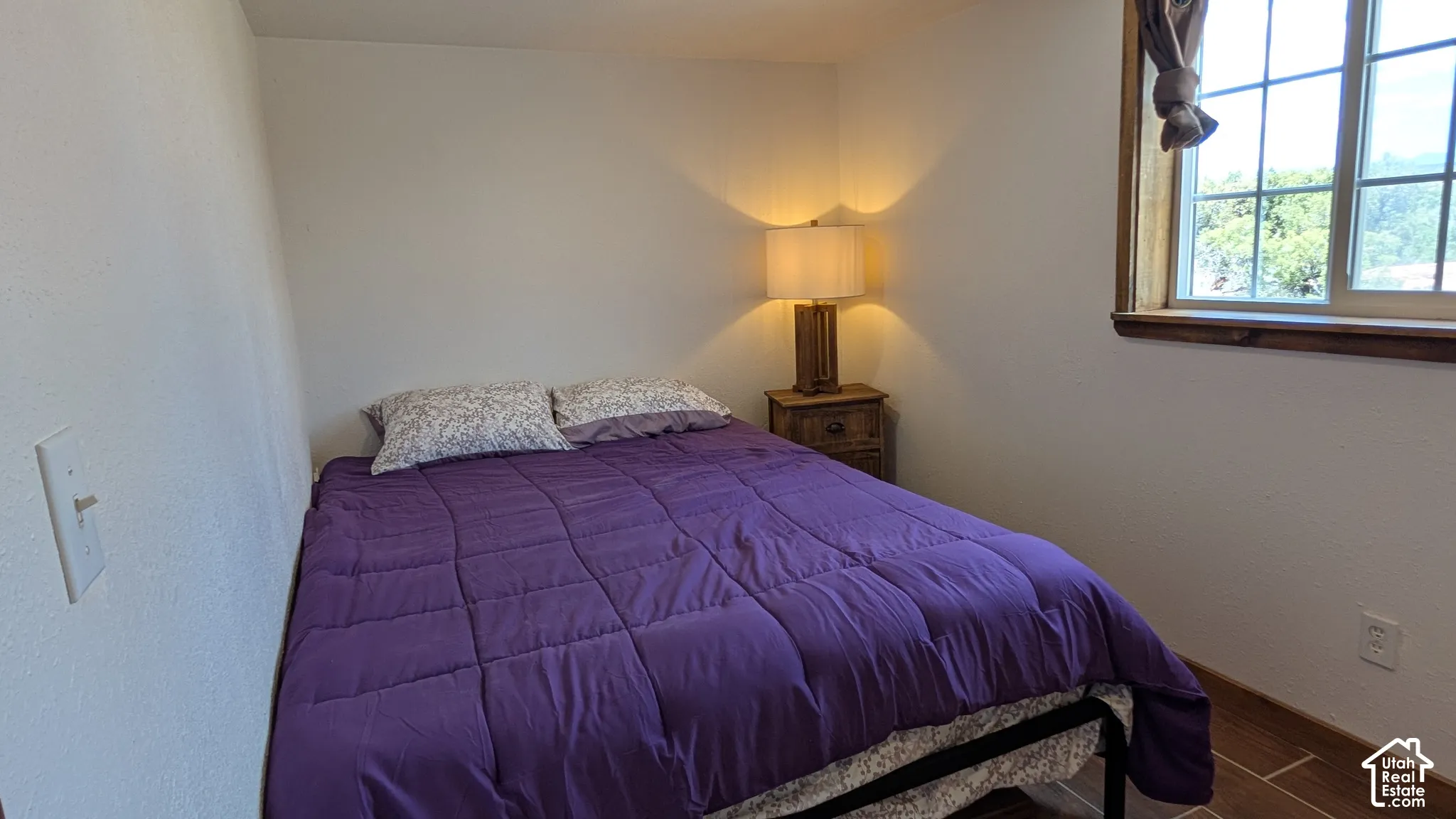 Room featuring wood-finish tile flooring and a multi-pane window with wood-trim framing